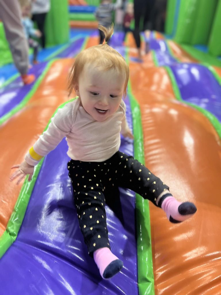 Close-up of a smiling little girl bouncing on the jump pad during Little Leapers time at MaxAiir inflatapark in Marion, Ohio