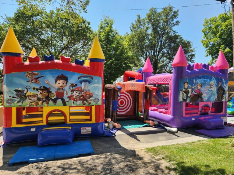 Paw Patrol and Frozen themed bounce houses set up outdoors at a MaxAiir Party Rentals event on a sunny day