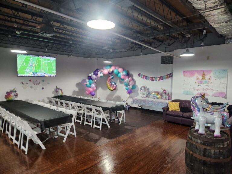 Unicorn-themed birthday party setup in the Golden Token party bay at MaxAiir with pastel balloon arch, unicorn decorations, and Happy Birthday banner